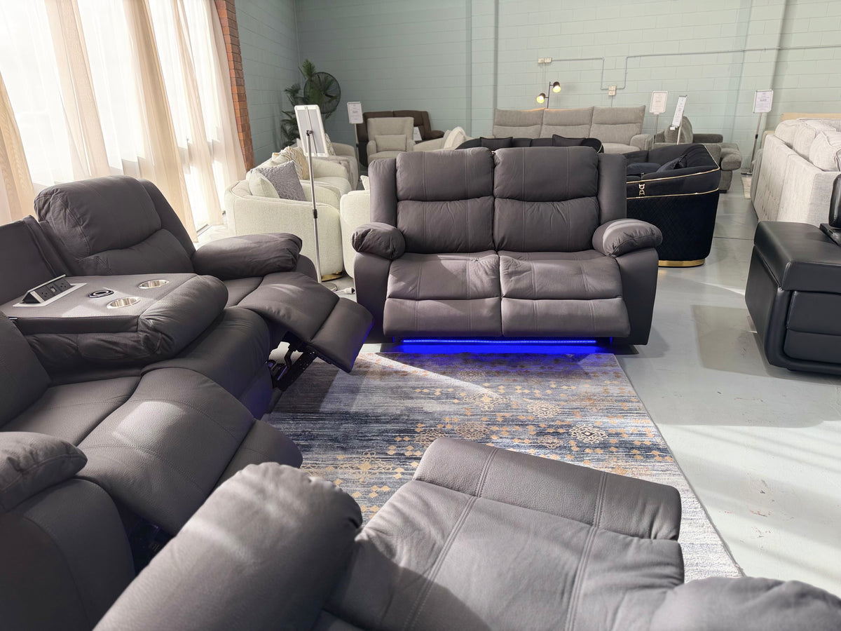 JASON 3 seater with the console down and a seat reclined, with the JASON 2 seater and LED lighting behind, in black Rhino fabric