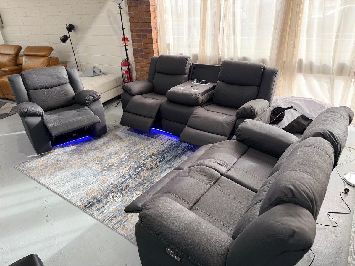 Room view of the JASON armchair, 3 seater and 2 seater in black Rhino fabric, console open and LED base lighting on